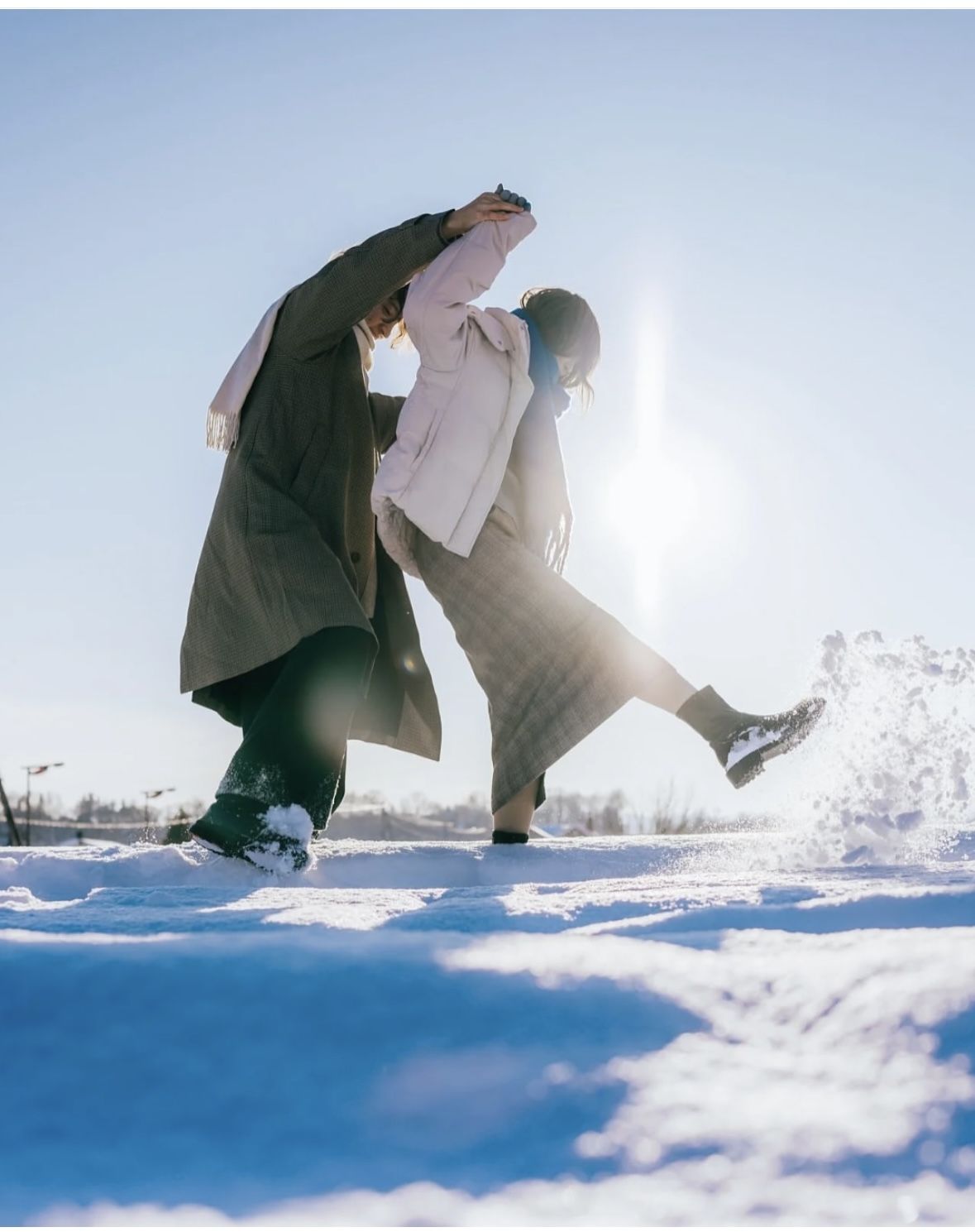 阳光下在雪地里起舞的两个人